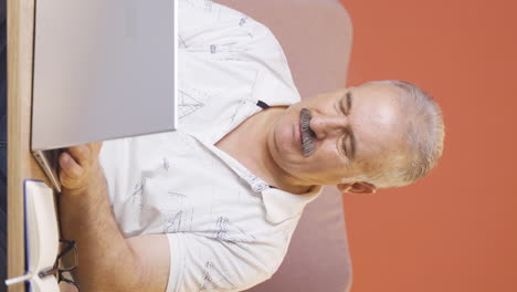Vertikales-Video-Des-Negativen-Gesichtsausdrucks-Eines-Alten-Mannes,-Der-Einen-Laptop-Benutzt.