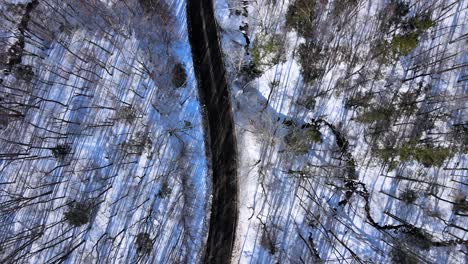 Luftdrohnenaufnahmen-Von-Oben-Nach-Unten-Einer-Landstraße-Durch-Die-Schneebedeckten-Berge