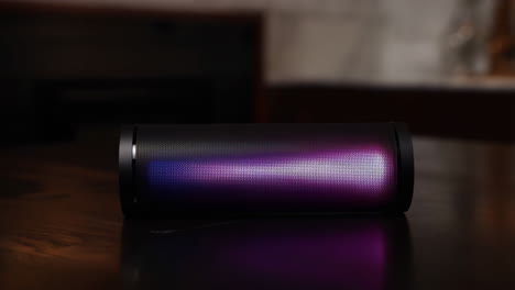 Portable Speaker with Changing LED Lights on a Dark Table
