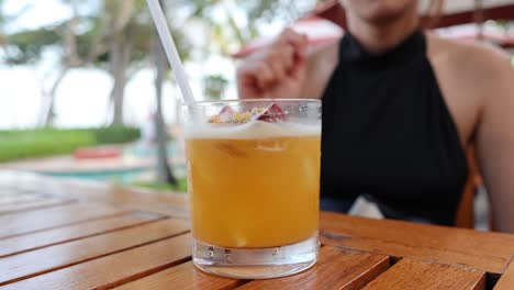 persona bebiendo una bebida fría de naranja en una mesa