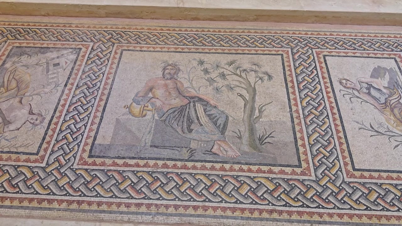 Primo piano cinematografico in 4K del mosaico dei Dei Fluviali Romani nel Museo di Zeugma. Presenta raffigurazioni dettagliate di Eufrate, Acheloo e Peneo dall'antica Villa di Poseidone.