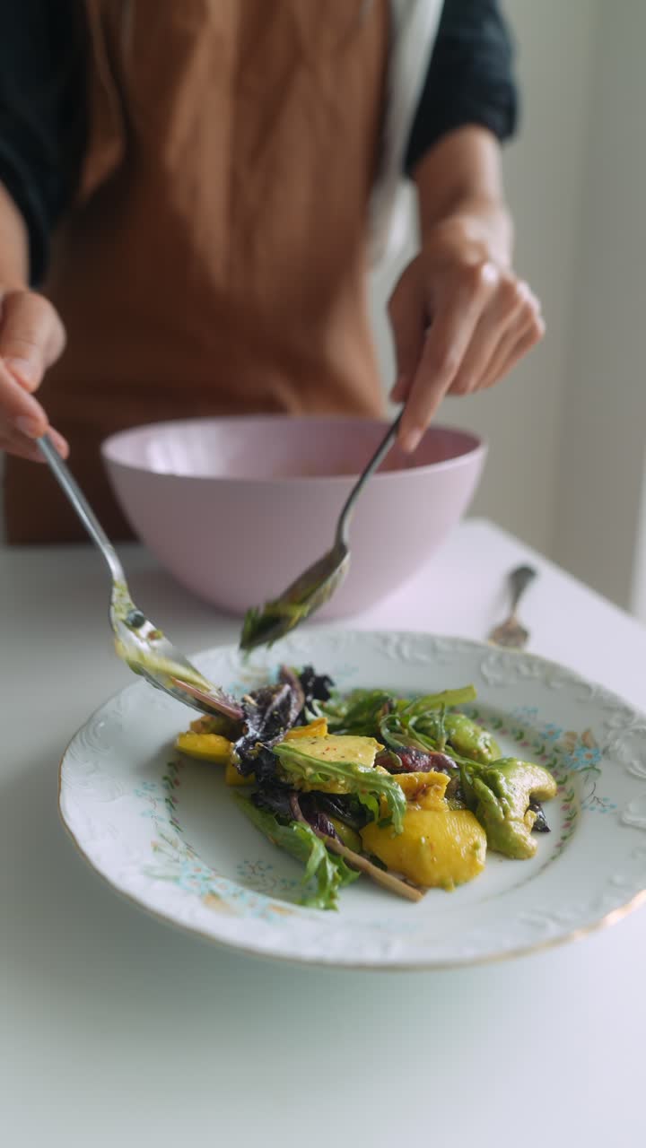 Close-up of Hands Serving Fresh Salad with Mango and Avocado