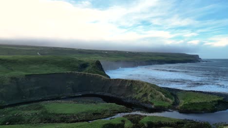 costa irlandesa verde salvaje con olas marinas ásperas chocando contra los acantilados en el fondo, doolin en irlanda