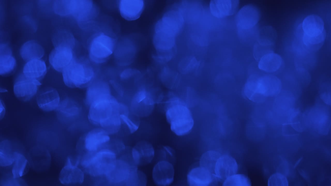 movimiento caótico de luces azules borrosas reflejadas en el agua.