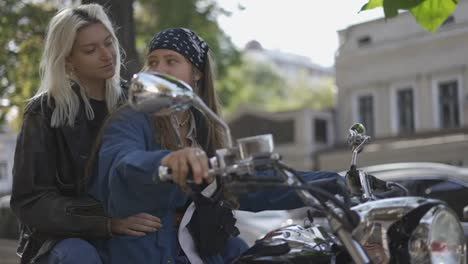 dos hermosas mujeres jóvenes en una motocicleta en la calle de la ciudad