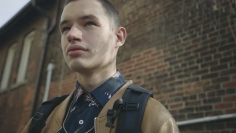 a young guy in the street turning his head in both sides observing around - low-angle shot, slow motion