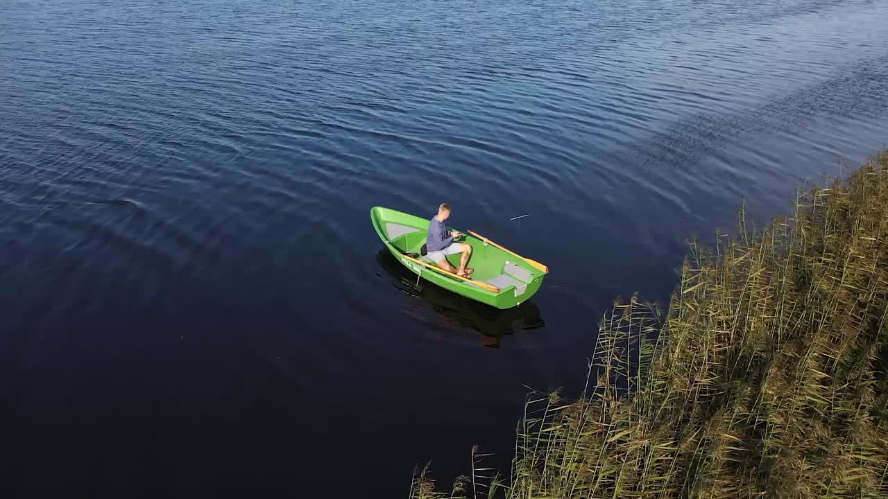 Above the Waters: Drone's View of a River, Fishing Boat, and Angler Amongst Reeds