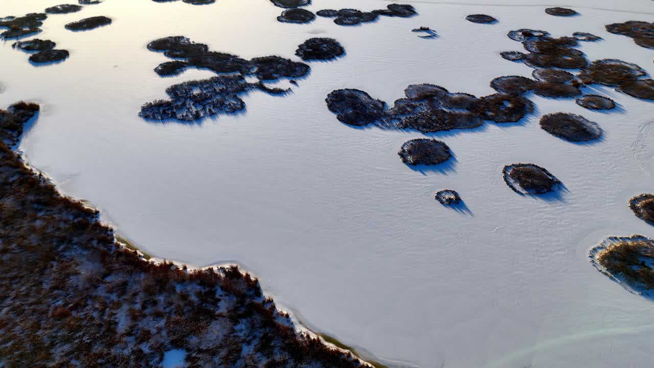 Aerial view of a frozen lake with snow-covered islands in the middle