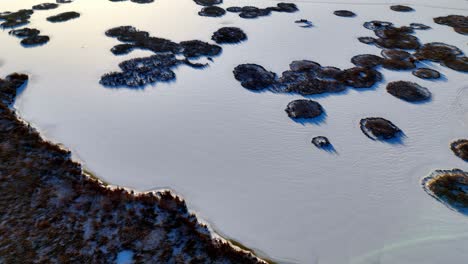 aerial view of a frozen lake with snow-covered islands in the middle