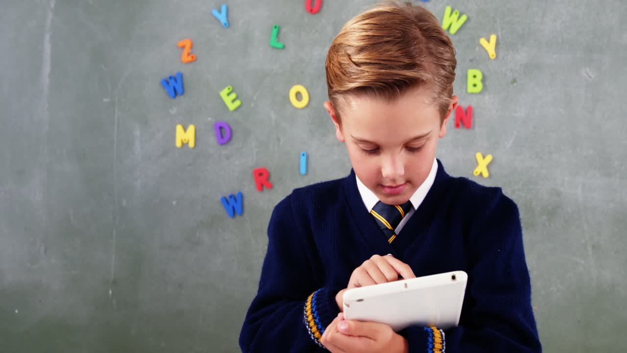 교실 에서 디지털 태블릿 을 사용하는 학교 소년