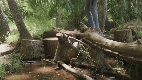 Low-section-of-african-american-couple-wearing-backpacks-and-hiking-in-forest,-slow-motion