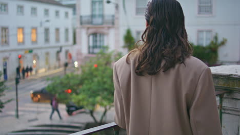 stylish woman contemplating urban view standing at metal railings alone close up