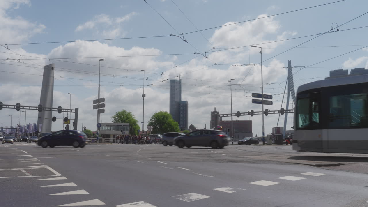 Two trams pass each other at a busy intersection.