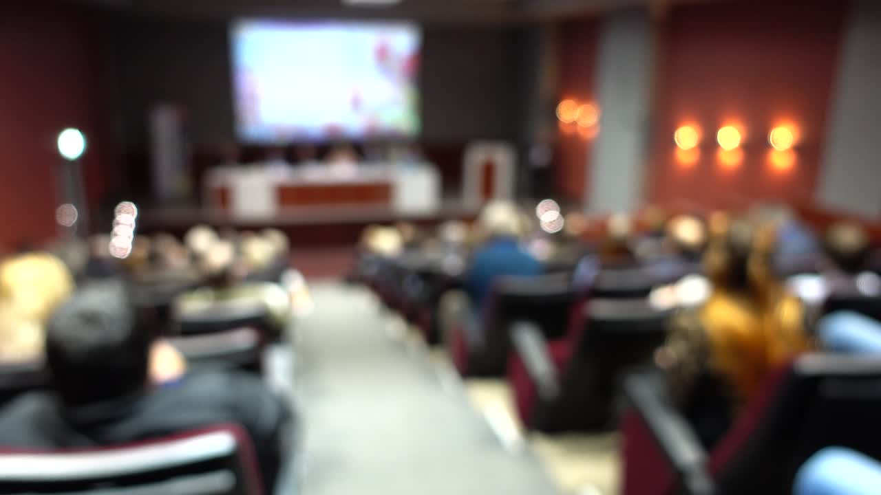Blurred View of Audience Attending a Conference Presentation