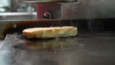 tostar un bollo en la plancha superior plana - serie de camiones de comida