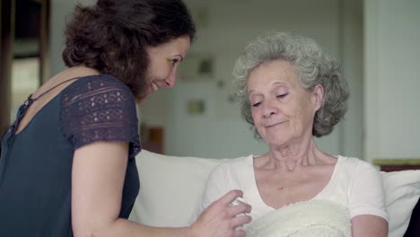 Daughter-coming-to-her-grey-haired-mothers-bed,-giving-her-pills