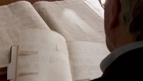 a man looks over some old historical books in a library in belfast