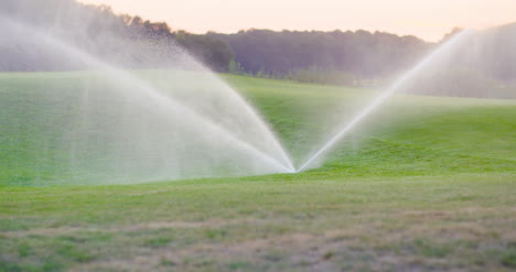 Mittlerer-Schuss-Grassprinkler-Spritzt-Wasser-über-Den-Rasen-1