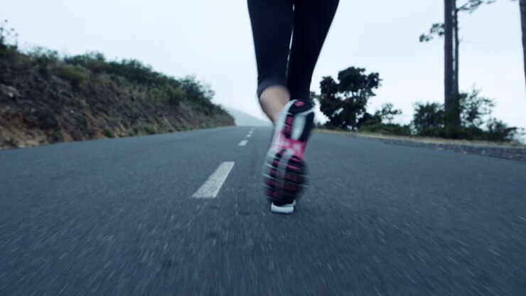 Donna che corre su una strada di montagna