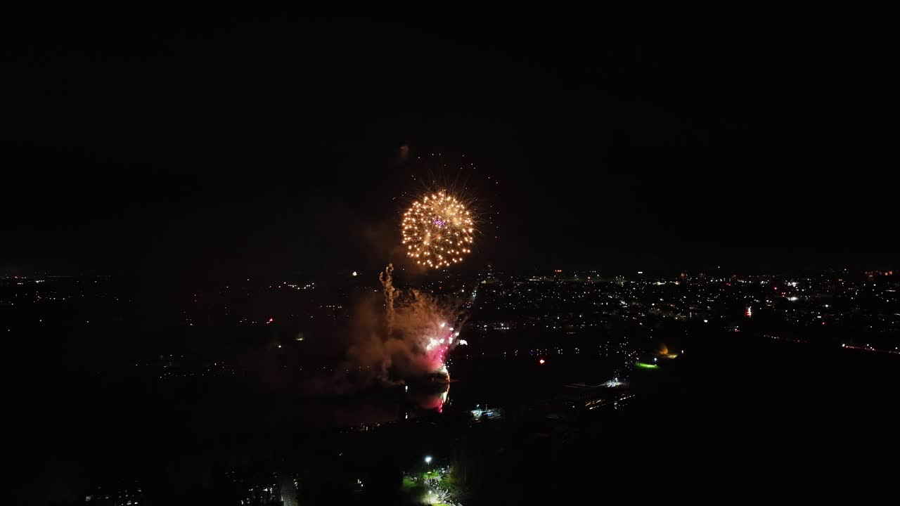 tomada aérea de fuegos artificiales vibrantes que explotan por la noche en el reino unido