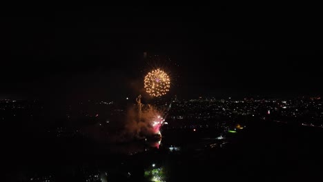 tomada aérea de fuegos artificiales vibrantes que explotan por la noche en el reino unido