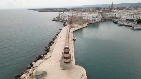 Toma-Aérea-De-Un-Dron-Empujando-Desde-Un-Faro-Hasta-La-Pared-De-Un-Castillo