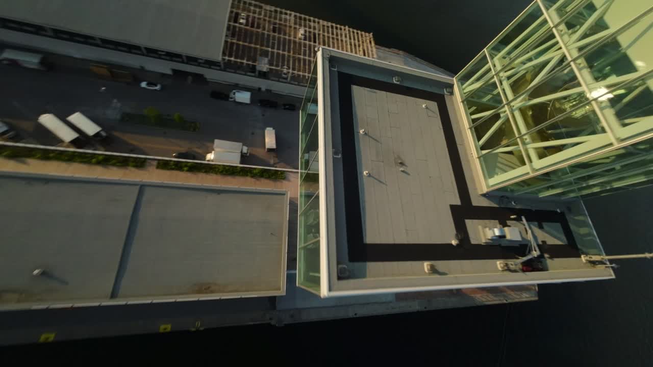 FPV drone reveals Port Tower rising from above, showcasing industrial textures and expansive views at dusk