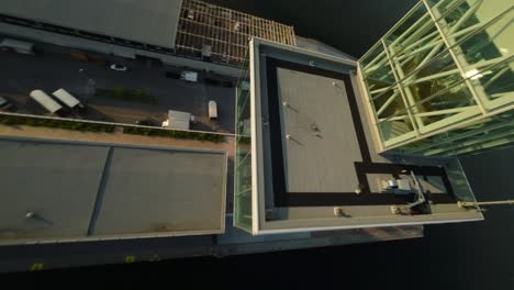 fpv drone reveals port tower rising from above, showcasing industrial textures and expansive views at dusk