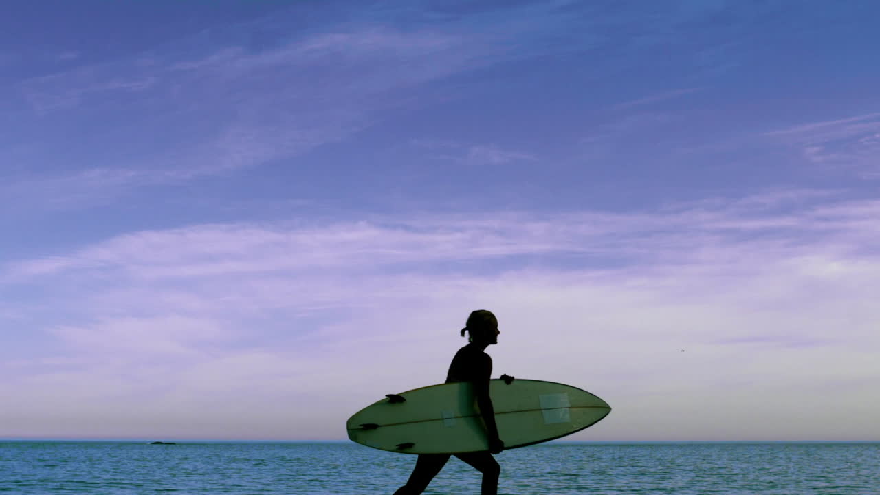 Donna che corre sulla spiaggia con la sua tavola da surf