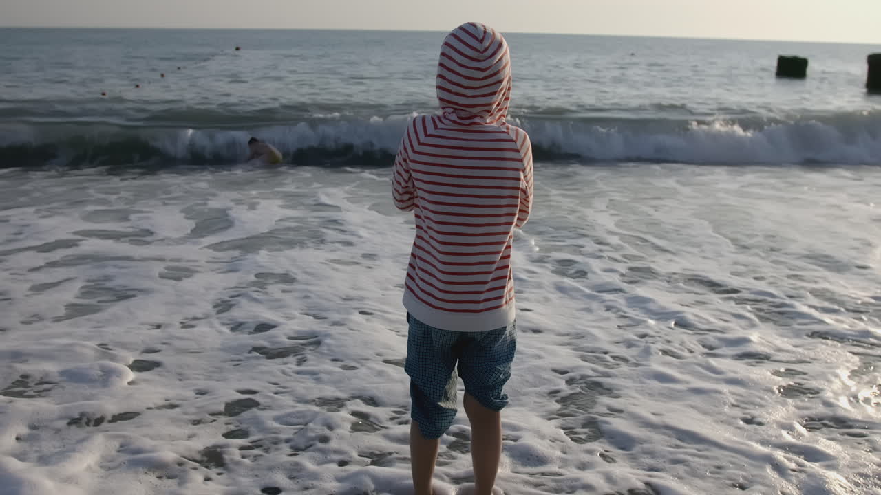 해가 지면 해변에서 놀고 있는 소년