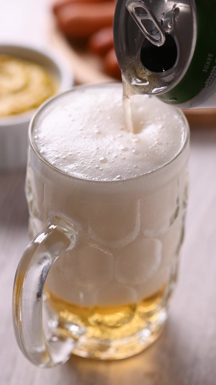 Pouring beer from a can into a glass mug