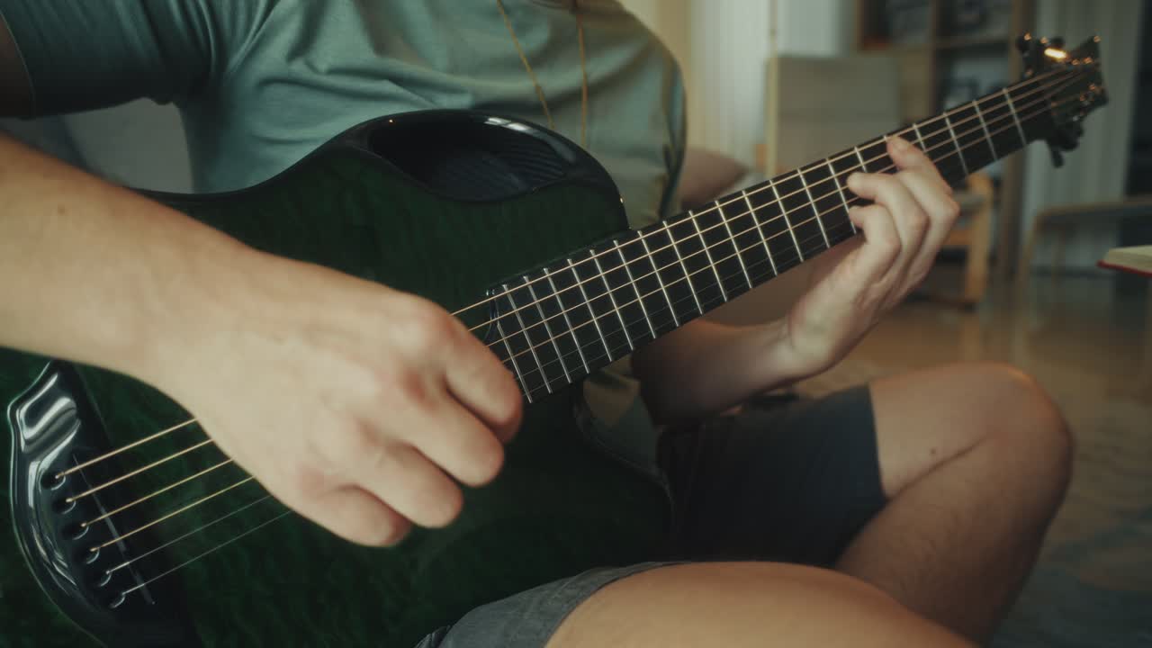 Primo piano di un musicista che suona una chitarra acustica verde