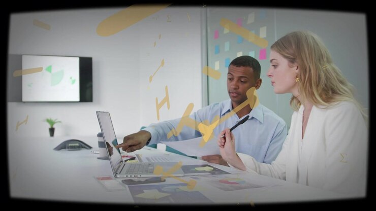 Male coworker pointing at laptop starting yellow overlay growing while team reading business papers