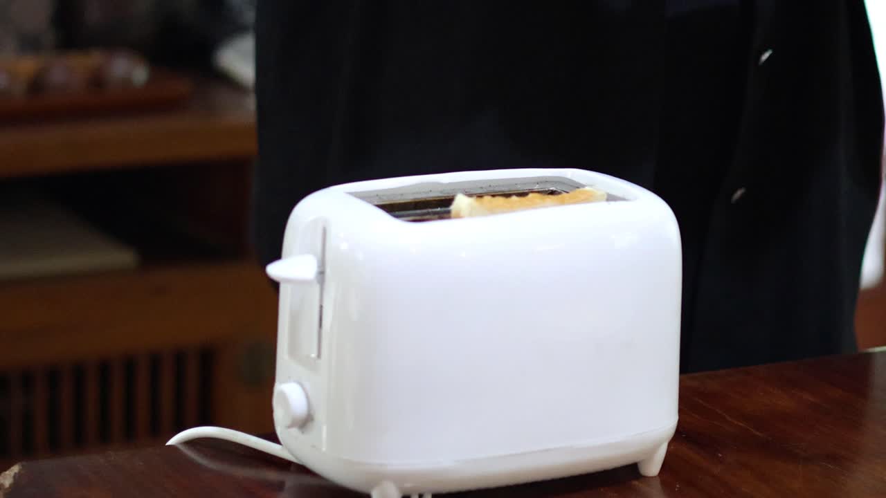 Person placing bread into a toaster
