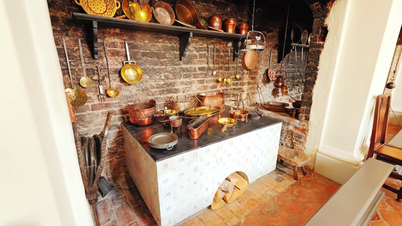 Wide angle camera glides slowly into historic baroque kitchen, rustic cookware