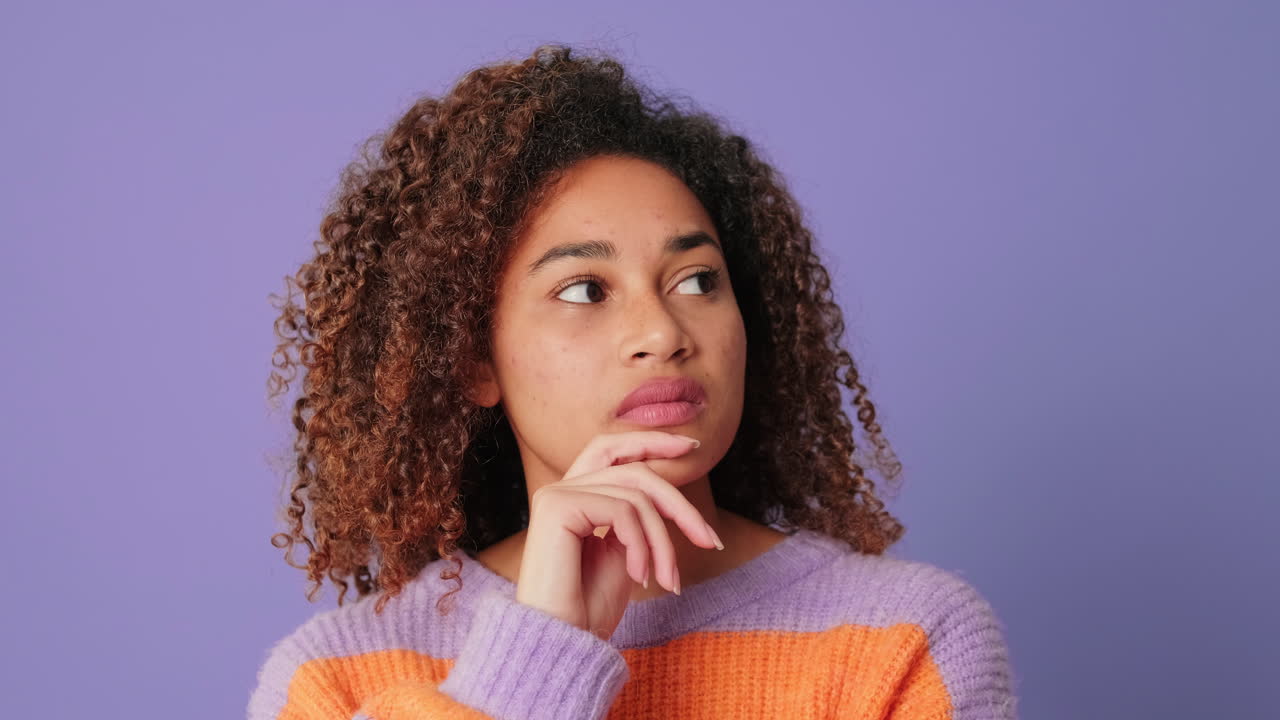 Woman with curly hair thinking and looking up