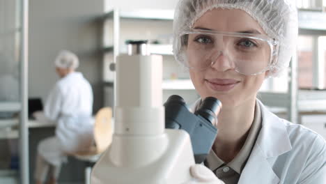 scientist looking through microscope in laboratory