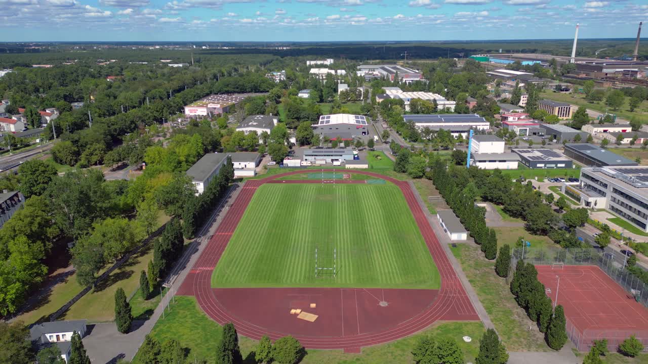 sports facilities at Hennigsdorf high school, including a soccer field, running track and other buildings in residential areas. Nice aerial view flight panorama overview drone