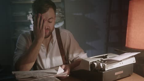 young writer concentrating on a new short story sitting at a table in a dark smoky office