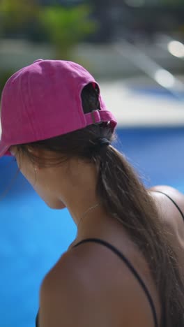 una mujer relajándose junto a la piscina.