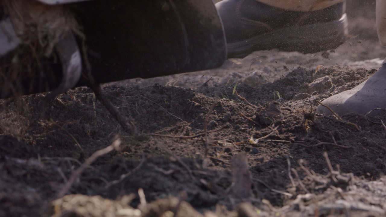 cuchillas de rototiller trabajando en tierra vegetal, agricultura, cámara lenta de cerca