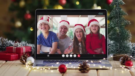 Glückliche-Familie-Mit-Weihnachtsmützen-Bei-Einem-Laptop-Videoanruf,-Mit-Weihnachtsdekorationen-Und-Baum