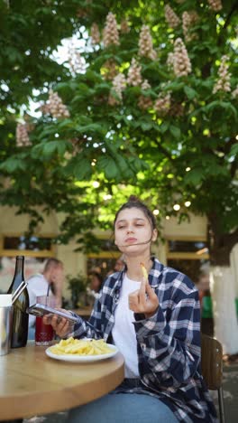 young woman eating fries in a cafe