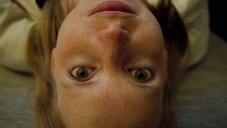 woman looks upside down directly at you