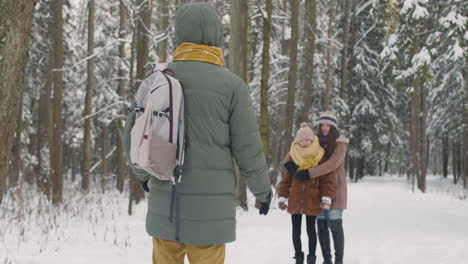 family playing in snowy forest