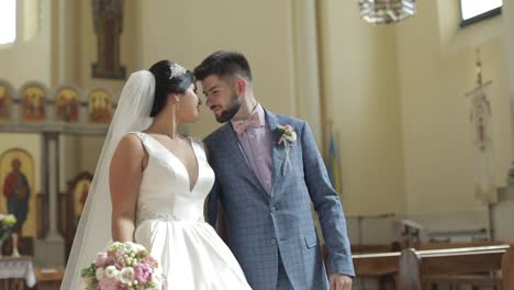 Elegant-bride-and-groom-walking-together-in-an-old-church.-Wedding-couple