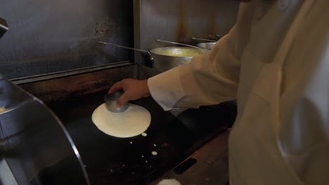 A-cook-in-an-Indian-restaurant-puts-batter-on-the-grill