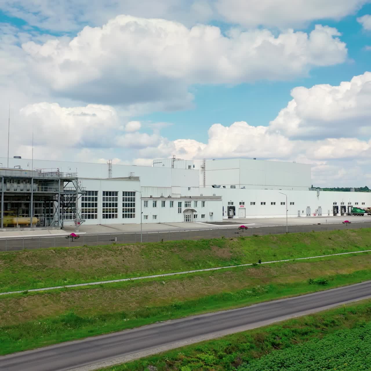 Contemporary industrial factory. Exterior of a large modern production plant in the countryside. Modern production company outdoors. Aerial view