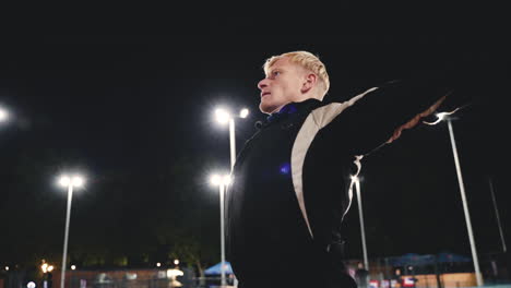 sportive blond man doing stretching exercises before training in the park at night 6