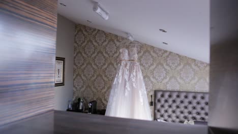 wedding dress hanging in a hotel room